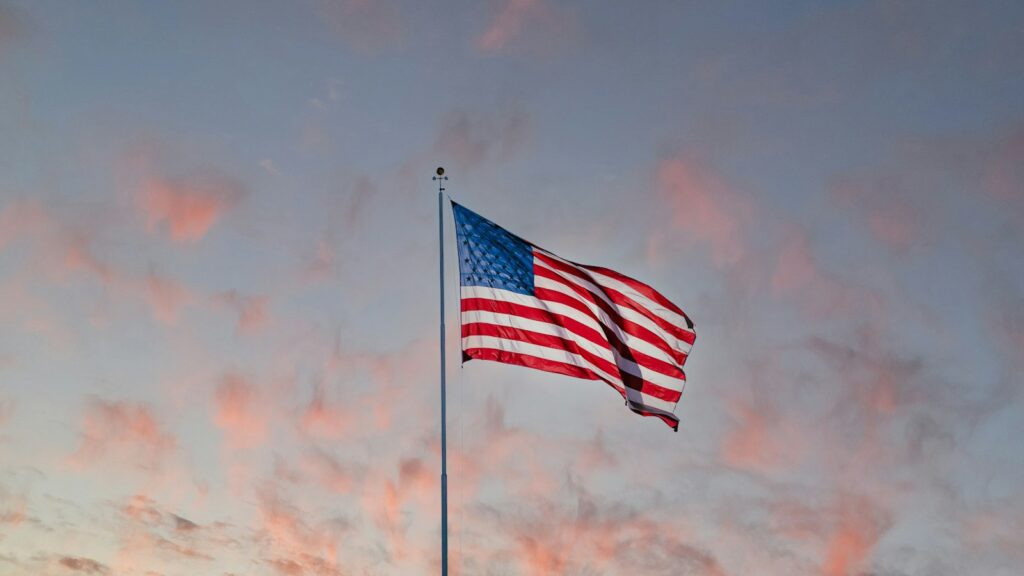 Usa us flag on a pole under a cloudy sky - FastUSTravel Dubai